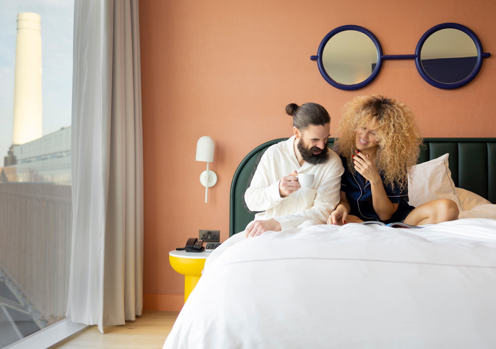 A man and a woman sitting on a bed in London